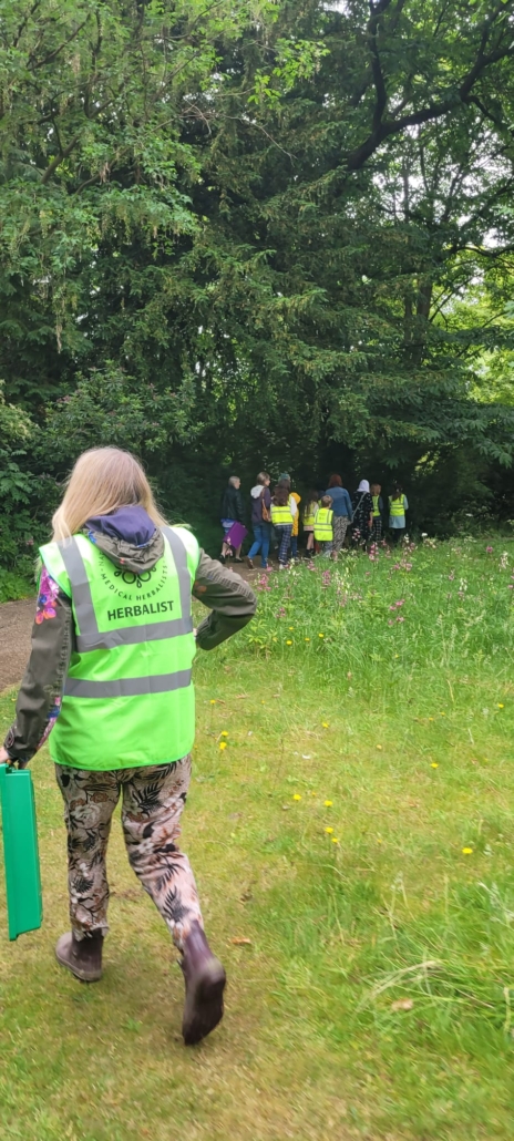 A photo of Chantal Perkins going on a herb hunt with the children attending the Junior Herbalist Club in the Botanical Gardens at Leicester.